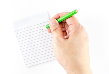 Hand holding green pencil writing on ruled note pad isolated on