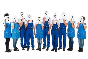 Fototapeta premium Janitors Hiding Faces With Question Mark Signs