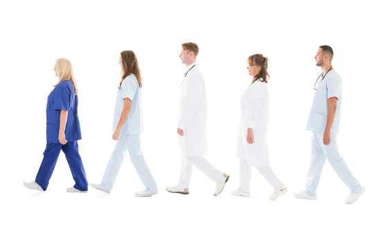 Side View Of Medical Professionals Walking In Row