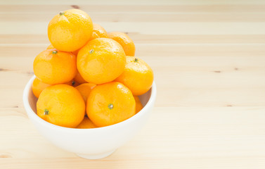 Mandarin or China Orange in White Bowl on Wood Table