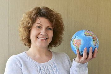 Woman with globe in hands thinking about traveling