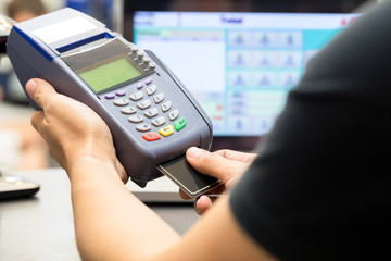 man’s hand with credit card swipe through terminal for sale in