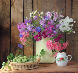Summer still life with a bouquet of phloxes  and a gooseberry.