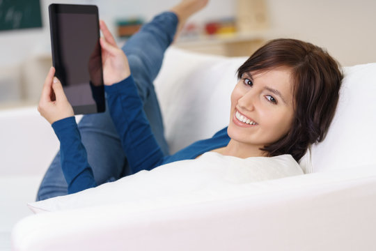 entspannte frau liest ein ebook auf dem sofa