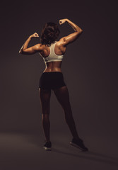 Athletic woman showing back and biceps muscles