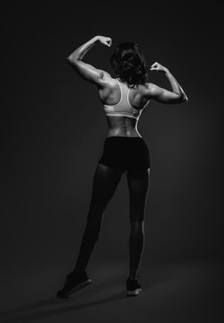 Athletic woman showing back and biceps muscles