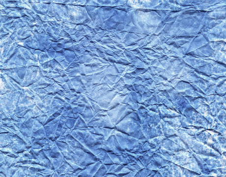 Texture of the wrinkled paper as a background.  Blue jeans color.