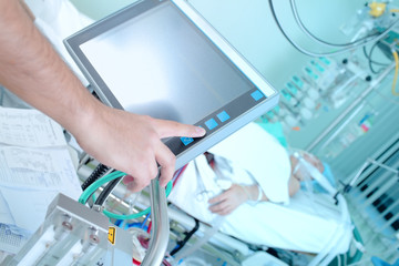 Doctor adjusting ICU equipment in the ward