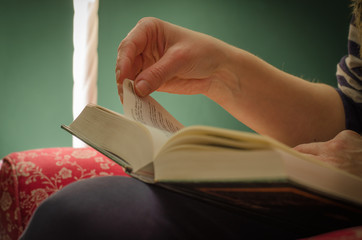 Woman hand folding down page of book