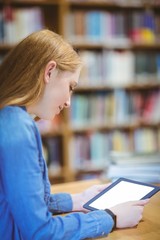 Student with smartwatch using tablet in library