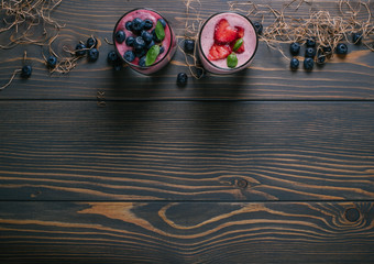 Smoothie with blueberries and strawberries on a wooden background with a free space top view