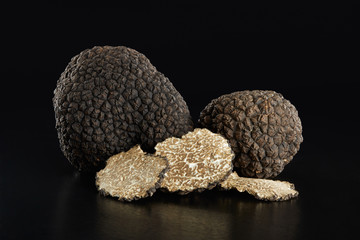 Black truffles and slices on black, clipping path included - obrazy, fototapety, plakaty