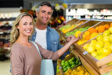 Happy smiling couple picking orange
