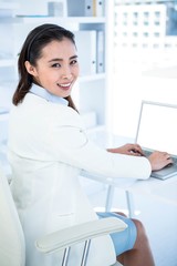 Smiling businesswoman using laptop 