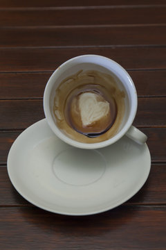 Cup of coffee with Heart of Coffee Grounds, on wooden table, fortunetelling, divination symbol of love