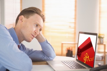 Naklejka premium Composite image of focused businessman looking at laptop