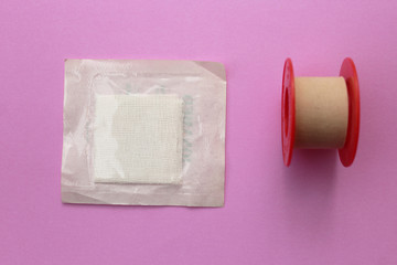 Bandage and gauze - first aid concept on purple background