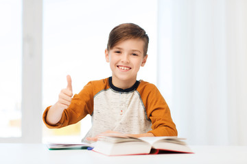 happy student boy with textbook showing thumbs up