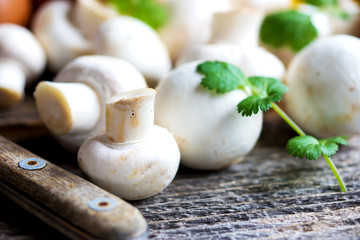 Fresh mushrooms champignons on wooden background 