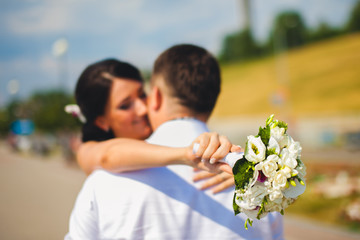 Cute adorable beautiful happy just married couple, stylish bouquet