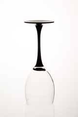 Empty inverted glass with black stem.