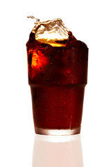 Splashing cola in glass. Isolated on white background