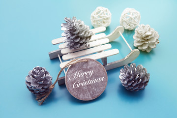 'merry christmas' on wooden tag with toy sleigh