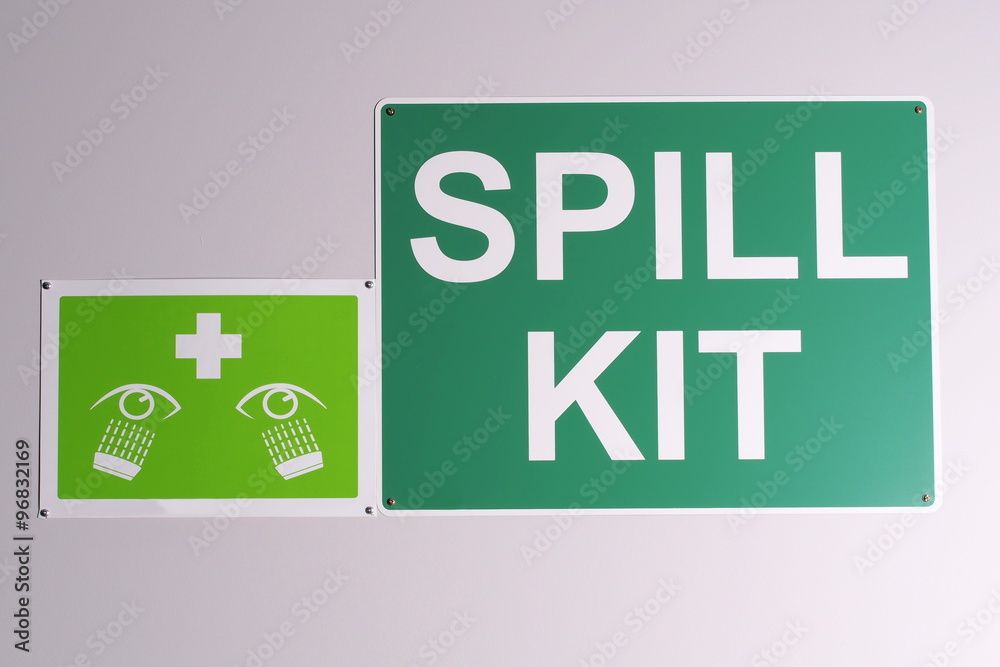 Wall mural emergency spill kit wall signs in green on off white background on a wall, australia 2015