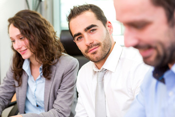 Young attractive businessman working at the office with associat