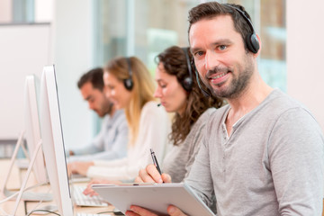 Fototapeta premium Young attractive man working in a call center
