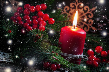 Christmas or New Year's dark composition with burning red candle