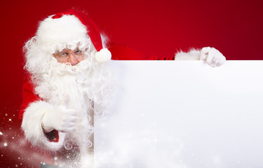 Santa Claus pointing in white blank sign with smile,christmas   - obrazy, fototapety, plakaty