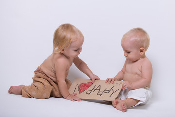 Two toddler holding a sign saying I love daddy