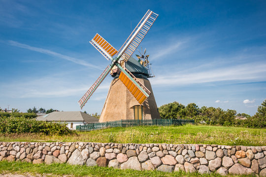 Traditional windmill in beautiful scenery with blue sky and clouds