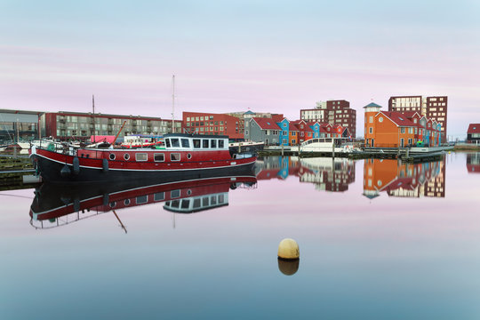 boat and colorful buildings on water at sunrise