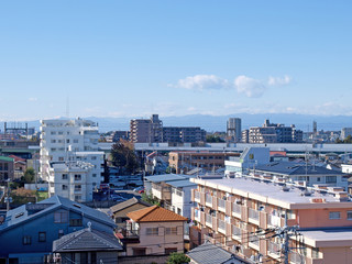 Naklejka premium Houses, mansions and a railway bridge in front of japanese mountains