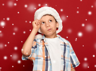 winter holiday christmas concept - boy in santa hat have idea on