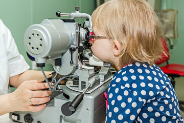 Optometrist with patient, giving an eye examination