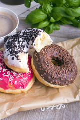donuts and cup of coffee on wood background