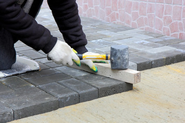 Worker installs paving slabs