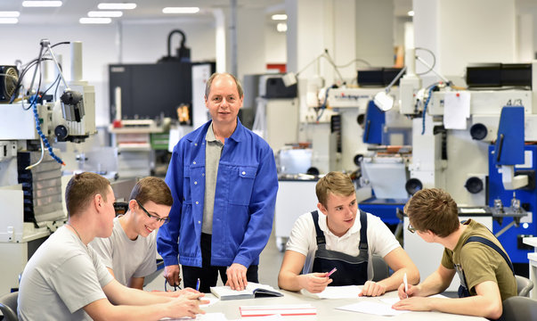 Meister in der Berufsausbildung mit Azubis im Bereich Metallverarbeitung- CNC Technik 