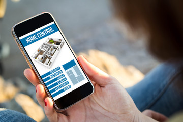 woman sitting in the street holding her smartphone with home con