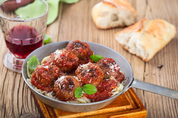 Homemade meatball with Italian pasta in frying pan 