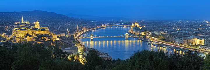 Fototapeta na wymiar Evening panorama of Budapest, view from Gellert Hill, Hungary. The panorama shows: Buda with Buda Castle, Danube river with Szechenyi Chain Bridge, Pest with Hungarian Parliament Building.