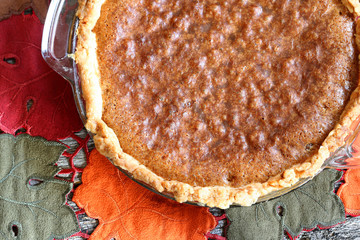 Whole chocolate chip pie ready for serving set in a fall setting