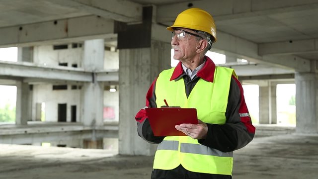 Job inspector in yellow hard hat at project site. Engineering supervision. Supervisory personnel at construction site
