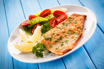 Fish dish - fried fish fillet baked potatoes and vegetables 