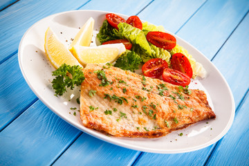 Fish dish - fried fish fillet baked potatoes and vegetables 
