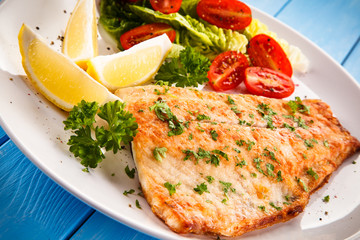 Fish dish - fried fish fillet baked potatoes and vegetables 