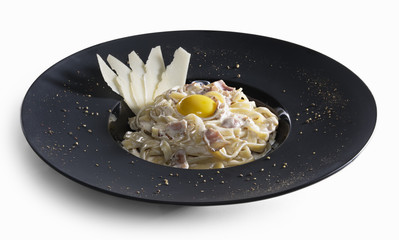 Pasta carbonara decorated with slices of parmesan and yolk isolated